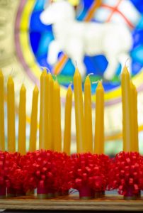 beeswax candles with Lamb stained class in background