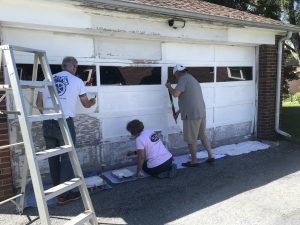 people painting garage exterior