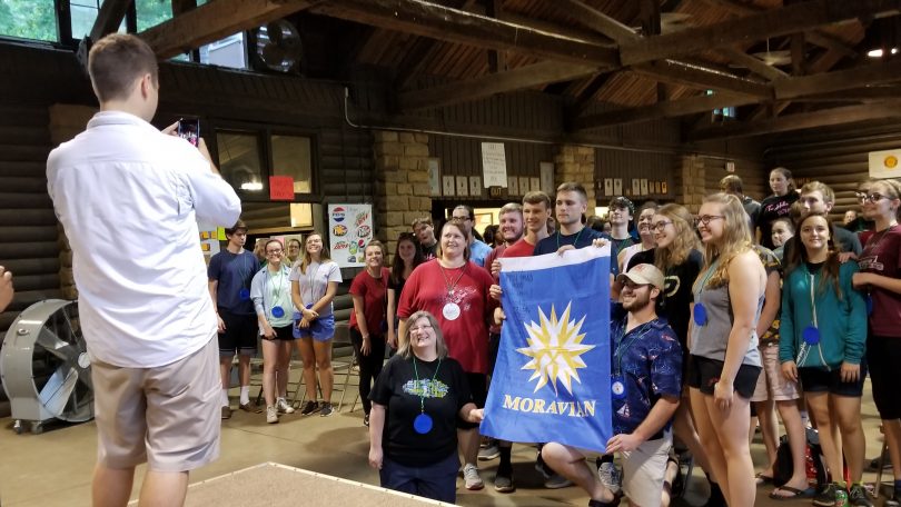 youth holding Moravian banner