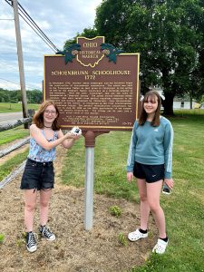 girls in front of Schoenbrunn schoolhouse sign