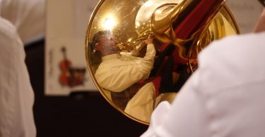 reflection of trombone player in brass
