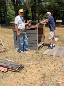 2 men building a wooden shelter