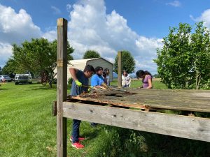 young people taking apart old deck