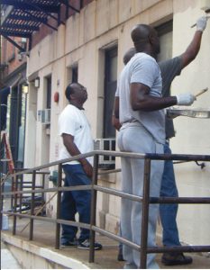 men painting exterior of building