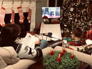 family in living room watching Christmas worship on TV